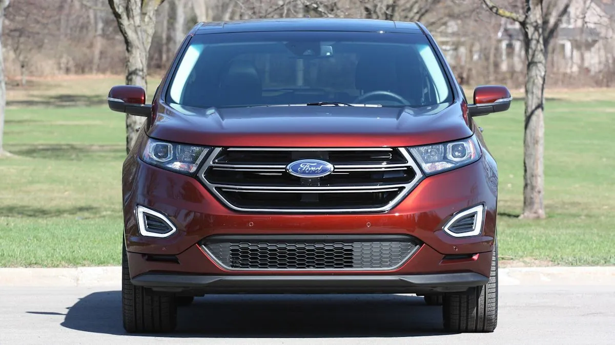 Un SUV Ford Edge roulant sur une route goudronnée en zone urbaine