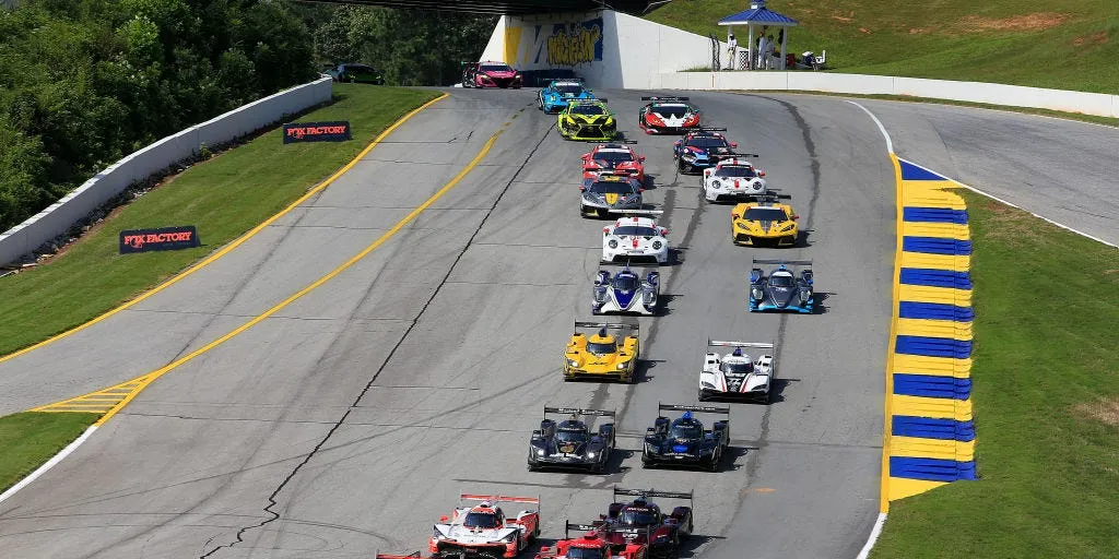 Le départ d'une course automobile internationale avec plusieurs bolides en compétition sur circuit